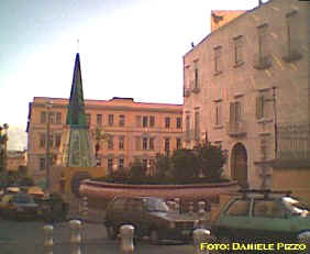 Uscita a valle: le decorazioni di Mimmo Paladino sull'edificio al civico 2, la guglia di vetri colorati, la grande aiuola con la statua di Pulcinella